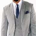 A man in a gray suit rental posing for a photo.