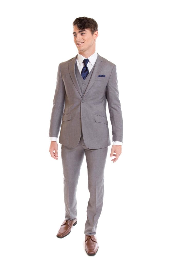 A man in an Allure Charcoal suit rental is standing on a white background.