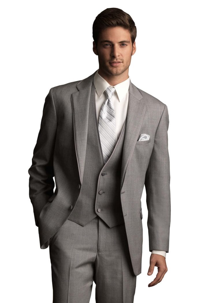 A man in an Allure Charcoal suit from a suit rental shop is posing for a photo.