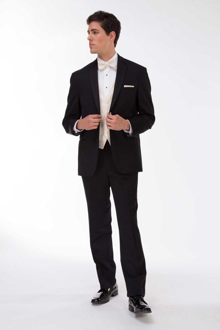 A man in a black Michael Kors Desire tuxedo rental posing for a photo.