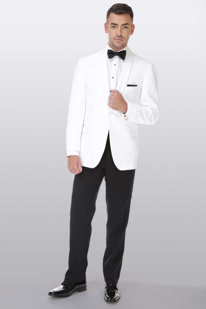 A man in a white tuxedo posing for a photo at an After Six Gerard suit rental shop.