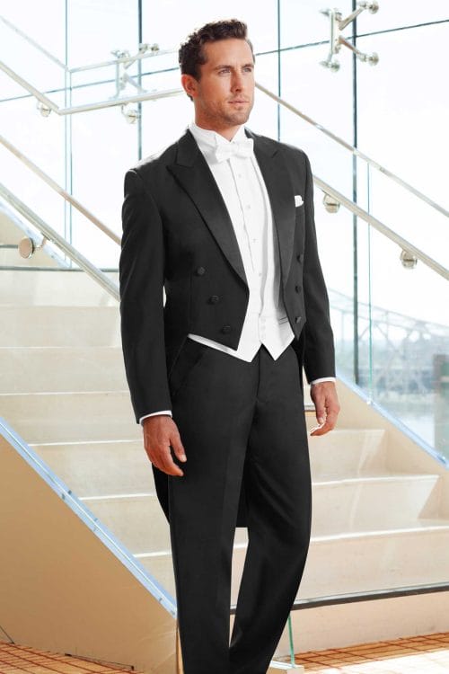 A man in a black tuxedo standing on stairs for an After Six Tails rental or tuxedo rental.