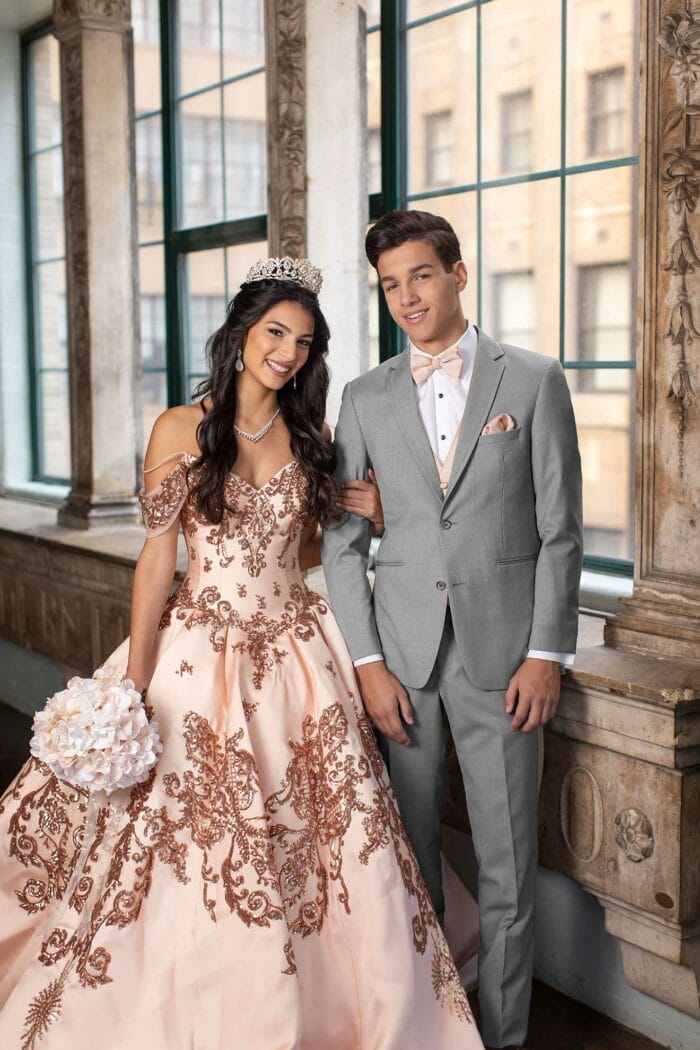 A man and woman are posing for a photo in formal attire from the Allure Heather Grey suit rental.