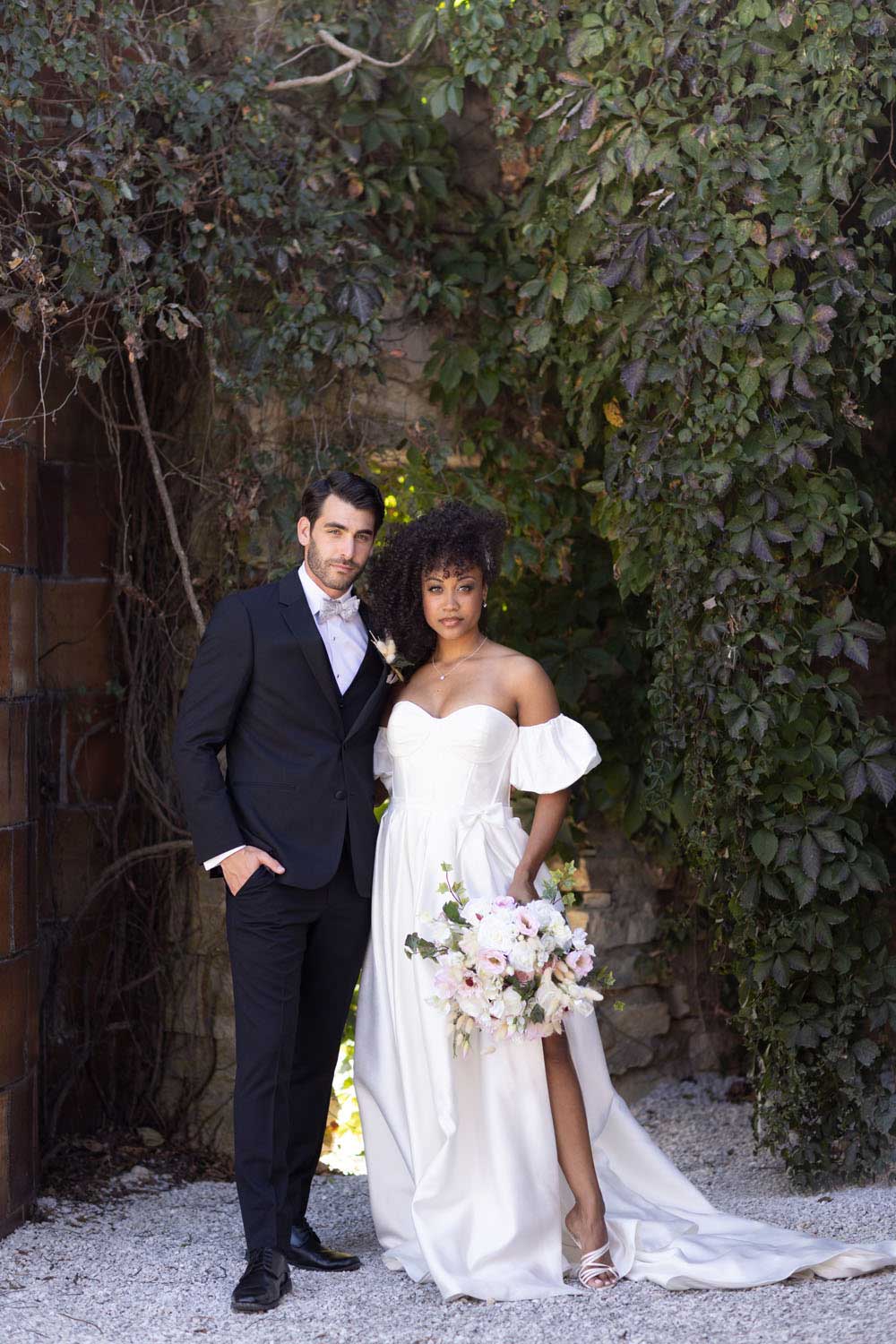 A groom posing for a photo in a garden, wearing the Michael Kors Black Performance.