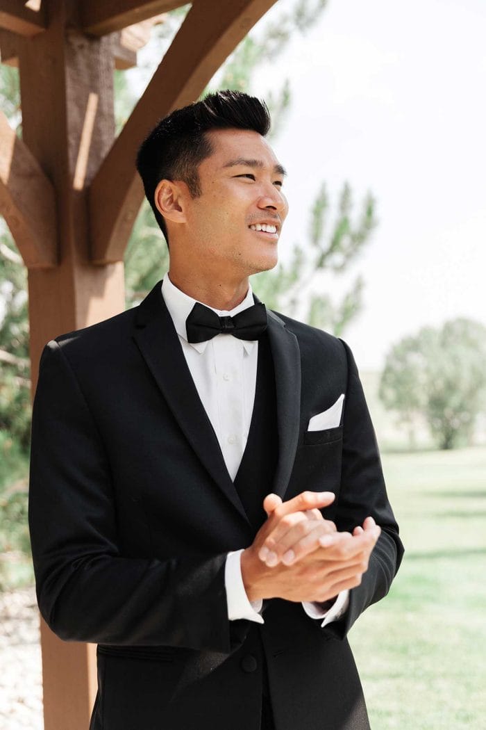 A man in a black Michael Kors Berkeley clapping during a formal event.
