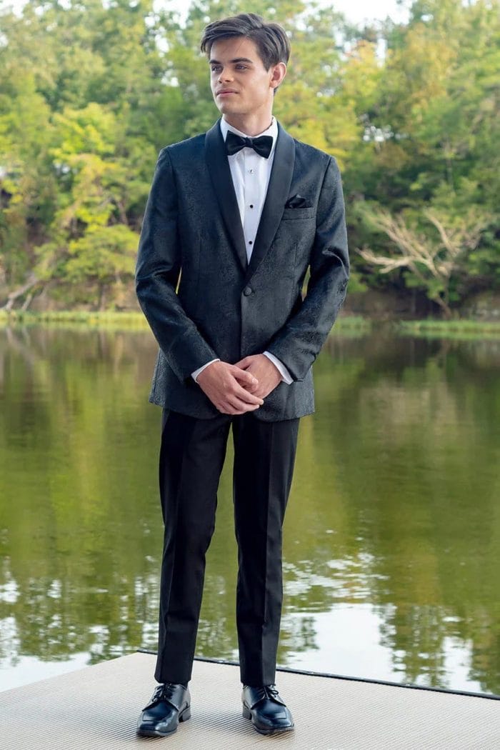 A young man in a Mark of Distinction Black Aries standing next to a body of water.