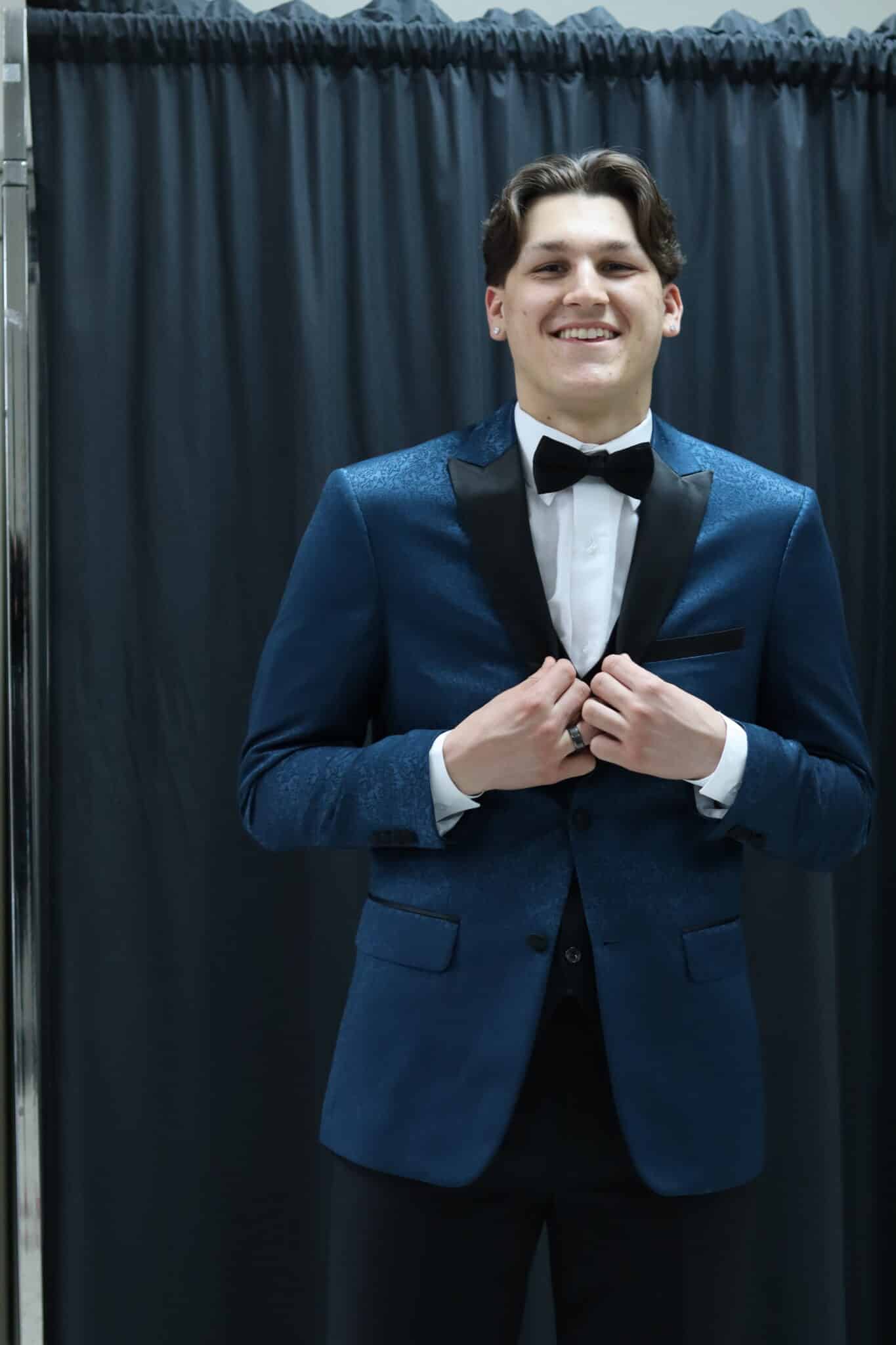 A young man in the Paisley Slim Fit Tuxedo posing for a photo during his tuxedo rental.